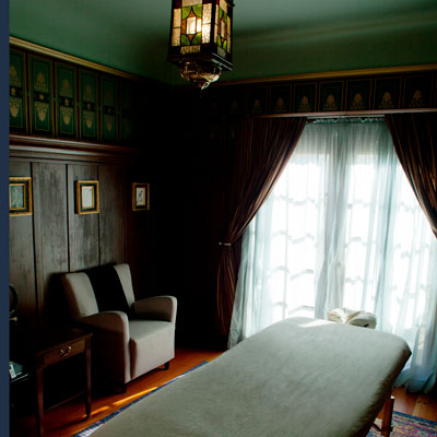 Treatment room at East West SF Bernal in San Francisco with massage table in front of large windows.